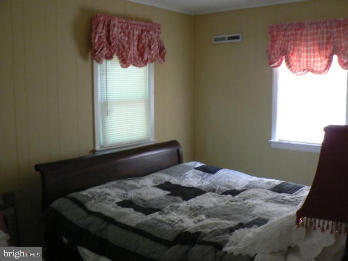 7423 Station Road Newcomb, MD 21653 - Photo 7 of 17 a bedroom with a bed window and a table