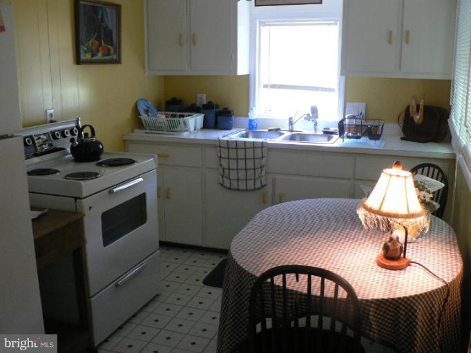 7423 Station Road Newcomb, MD 21653 - Photo 8 of 17 a kitchen with a stove a sink and cabinets