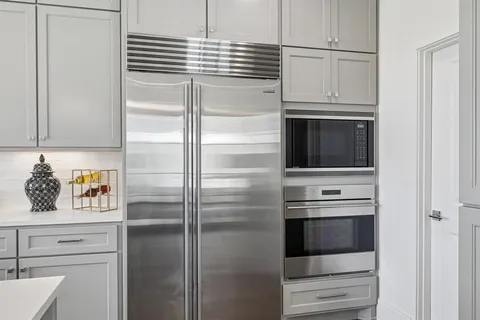 a kitchen with white cabinets and stainless steel appliances