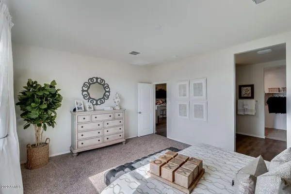 a bedroom with a bed and a potted plant