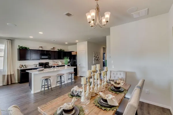 a living room with stainless steel appliances kitchen island granite countertop furniture a rug kitchen view and a chandelier