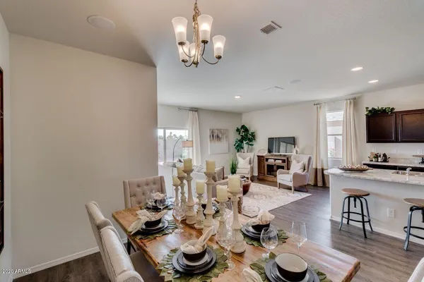 a view of a dining room with furniture a chandelier and wooden floor