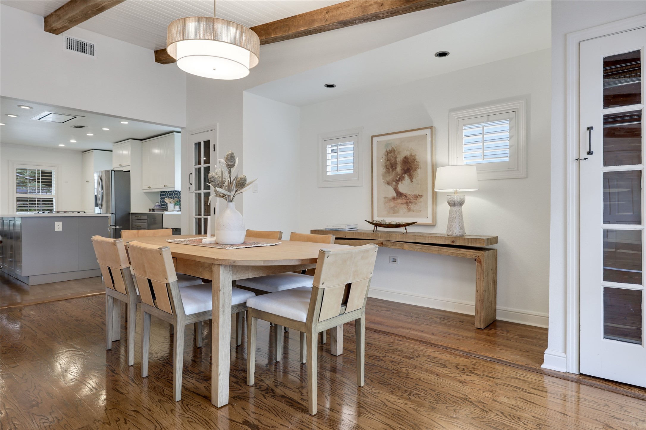 2908 Perry Lane Austin, TX 78731 - Photo 15 of 37 a dining room with wooden floor a chandelier a wooden table and chairs