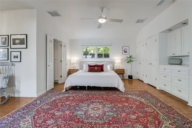 a spacious bedroom with a bed and a dresser