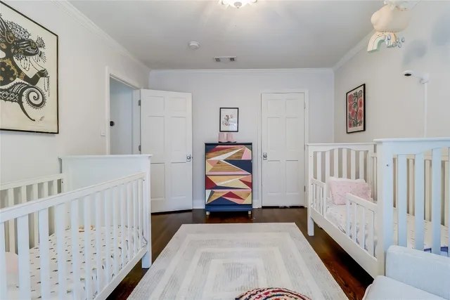 a bedroom with baby crib and wooden floor