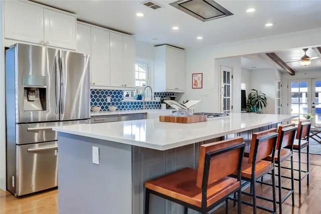 a kitchen with stainless steel appliances granite countertop a sink and a refrigerator