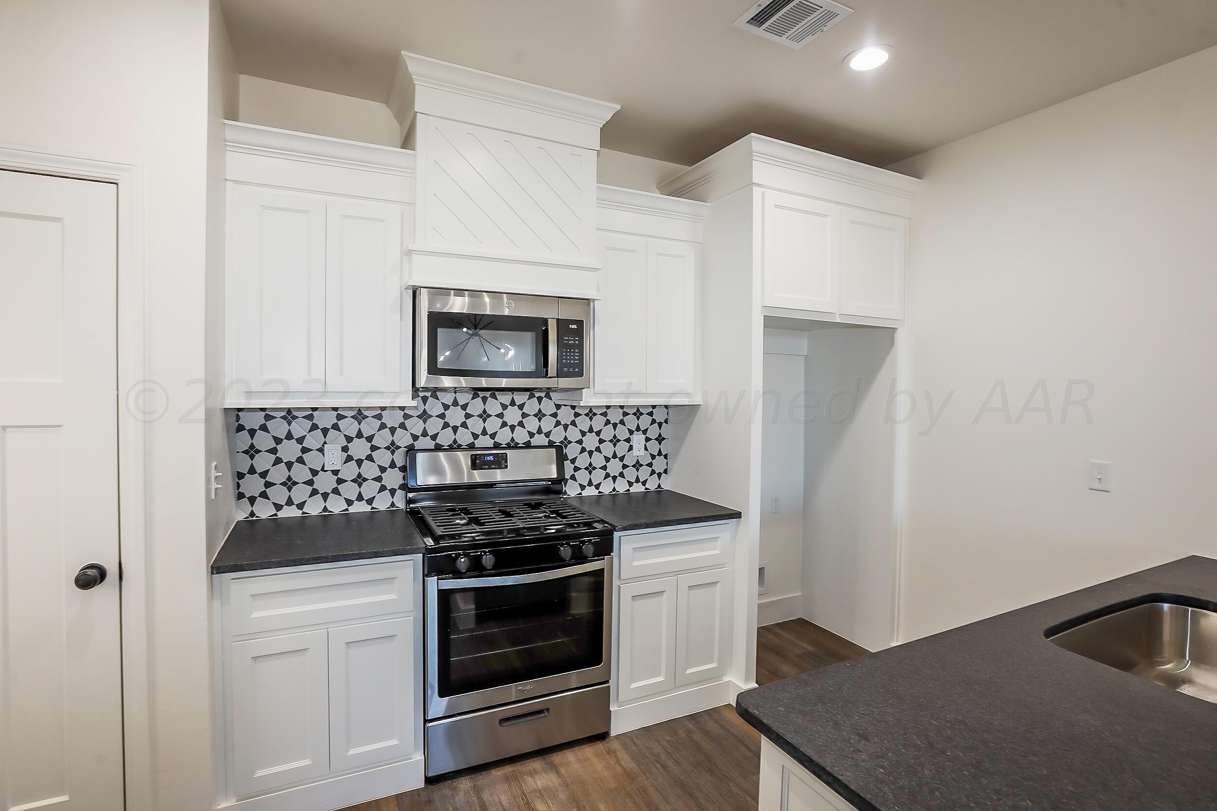 13771 Periwinkle Drive Amarillo, TX 79119 - Photo 3 of 23 a kitchen with a stove and a microwave