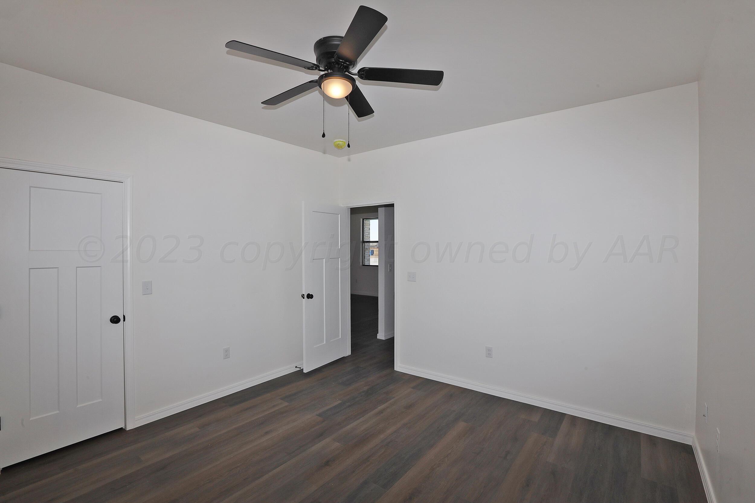 13771 Periwinkle Drive Amarillo, TX 79119 - Photo 9 of 23 an empty room with wooden floor ceiling fan and windows