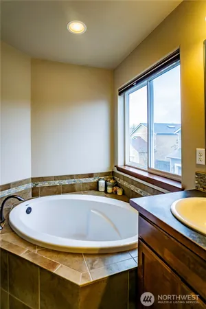 a bathroom with a tub and large window