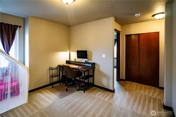 a view of a workspace with furniture and a window