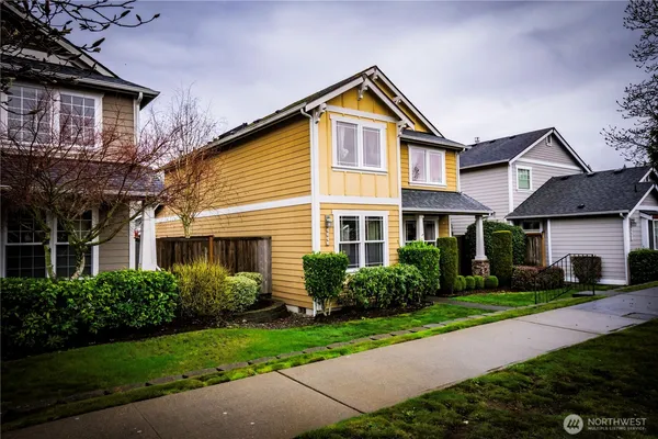 a front view of a house with a yard and potted plants