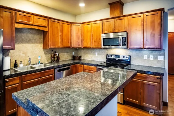 a kitchen with stainless steel appliances granite countertop a sink stove and refrigerator