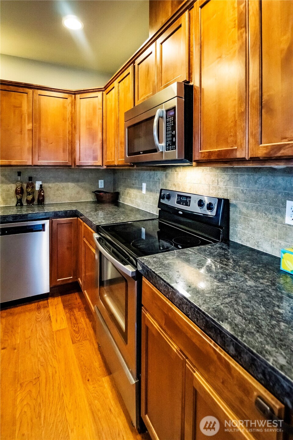 4646 Rochelle Street Southeast Lacey, WA 98503 - Photo 5 of 31 a kitchen with stainless steel appliances granite countertop a stove a sink and a microwave
