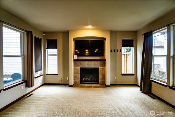 a view of an empty room with a fireplace and a window