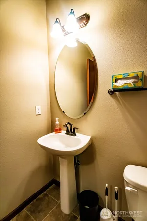 a bathroom with a sink mirror and toilet