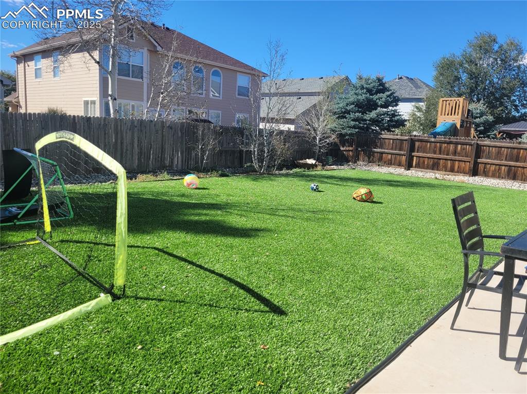 8975 Kingston Heath Road Peyton, CO 80831 - Photo 16 of 18 a view of a garden with a slide and a child swing