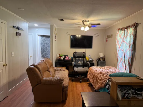 a living room with furniture a flat screen tv and a window