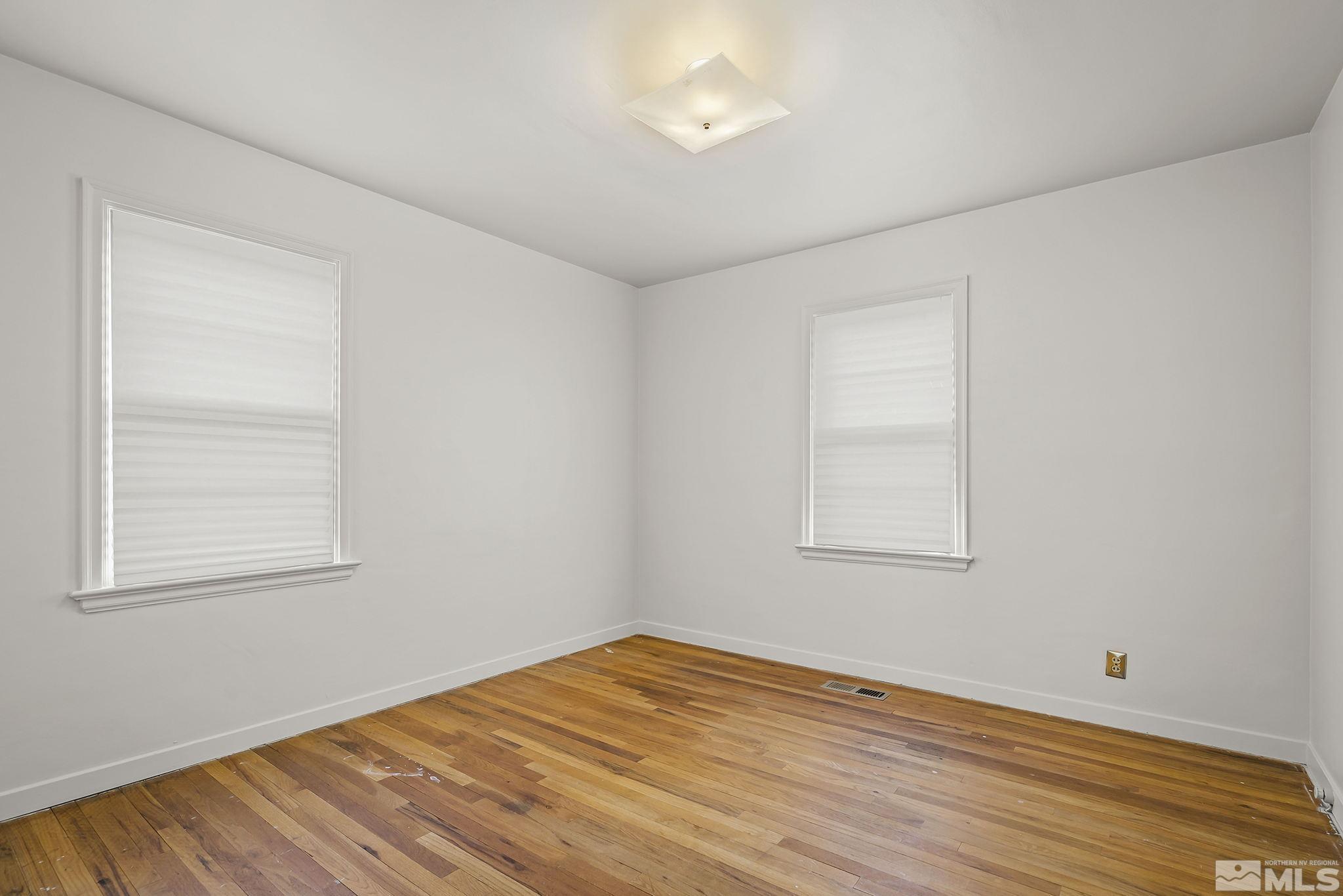 509 Toiyabe Street Reno, NV 89509 - Photo 8 of 14 an empty room with wooden floor and windows