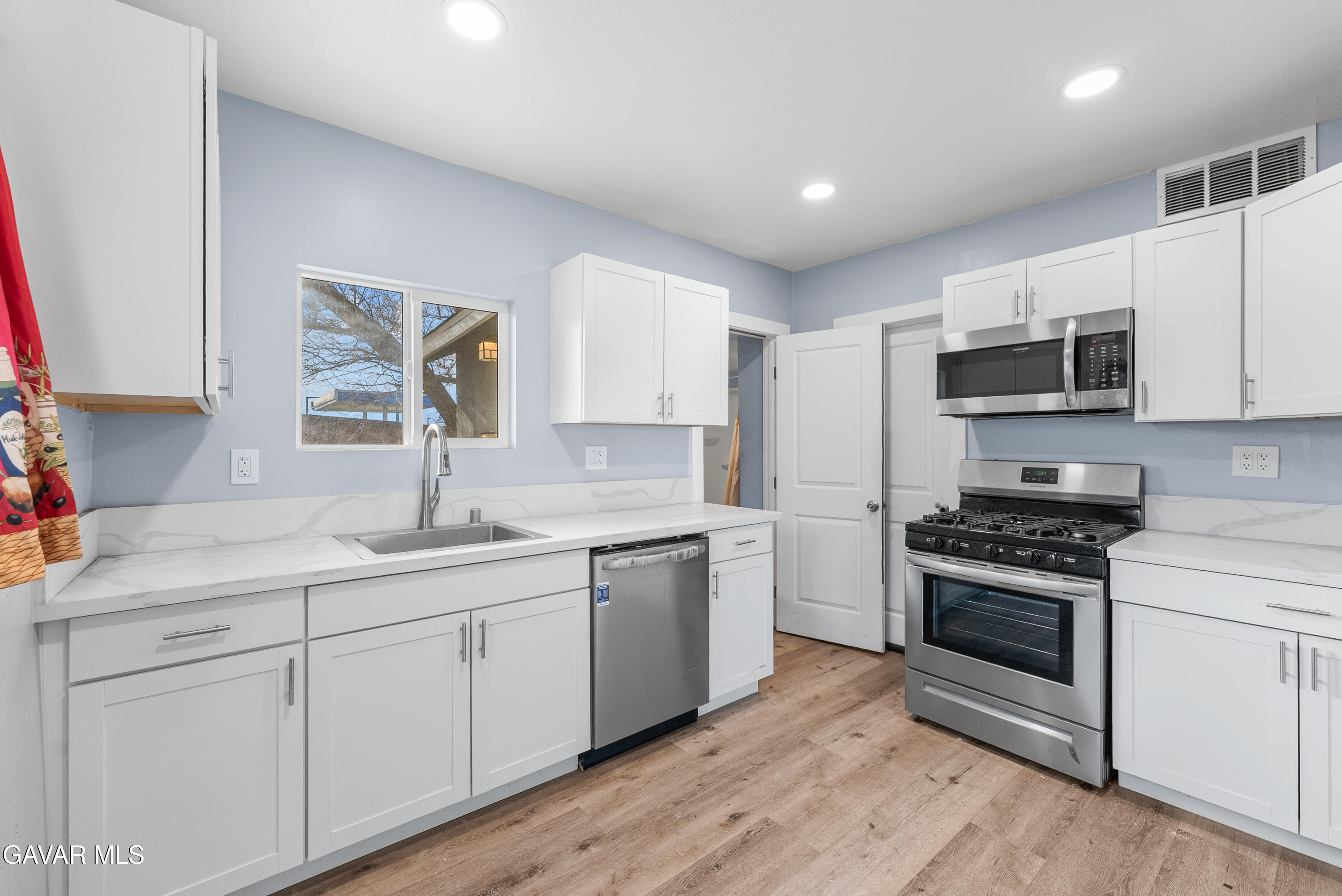 15733 K Street Mojave, CA 93501 - Photo 18 of 38 a kitchen with granite countertop white cabinets and appliances