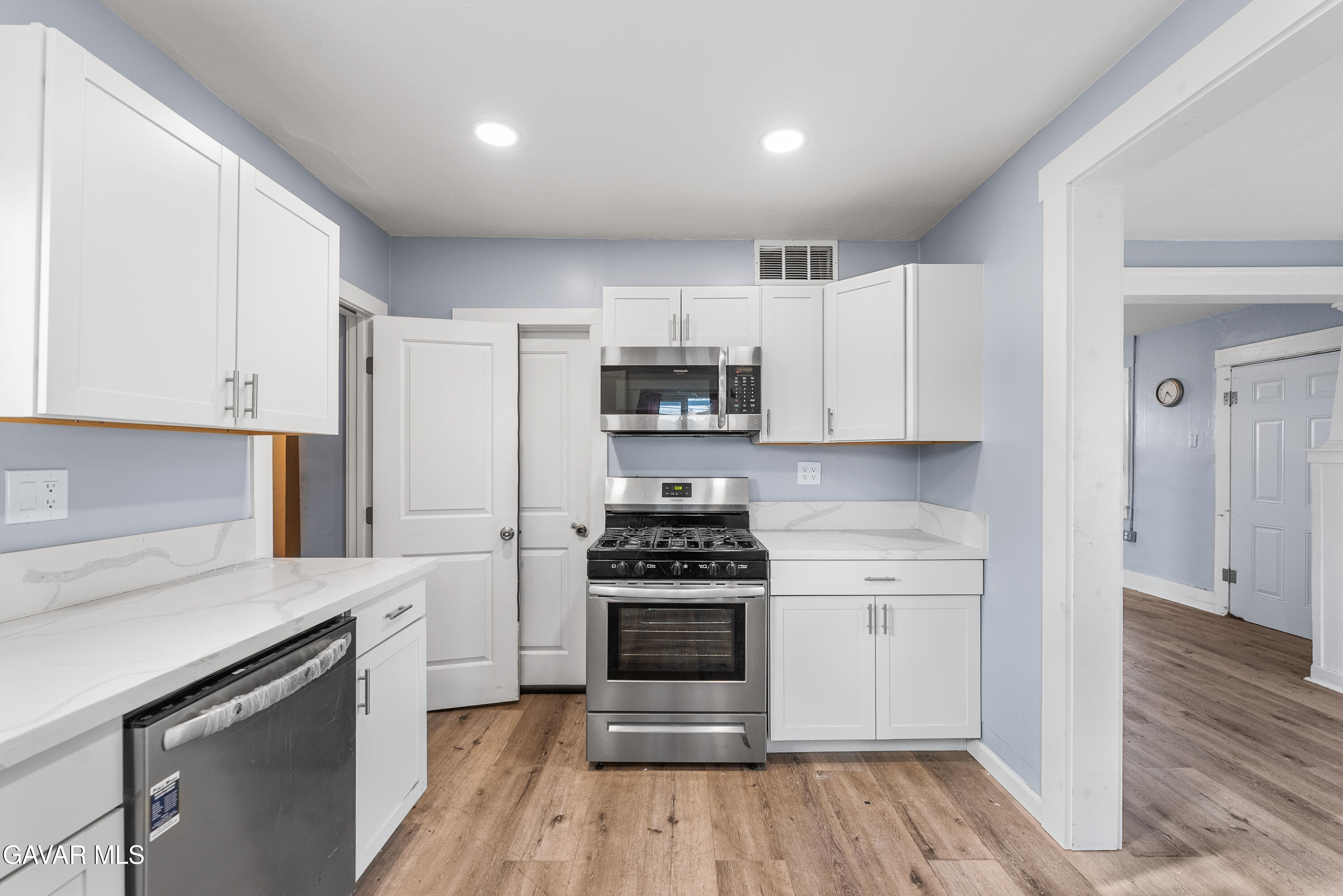 15733 K Street Mojave, CA 93501 - Photo 21 of 38 a kitchen with granite countertop white cabinets and stainless steel appliances