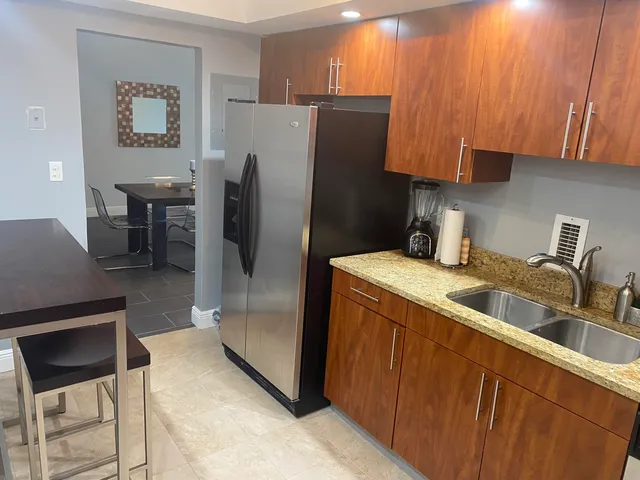 a kitchen with stainless steel appliances granite countertop a refrigerator and a sink