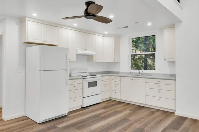 a kitchen with white cabinets and white stainless steel appliances