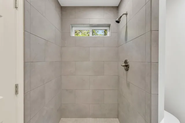a view of hallway with window and wooden floor