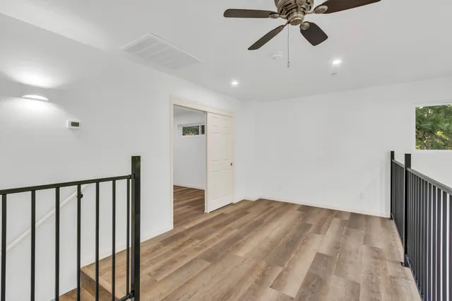 a view of a hallway with wooden floor and staircase