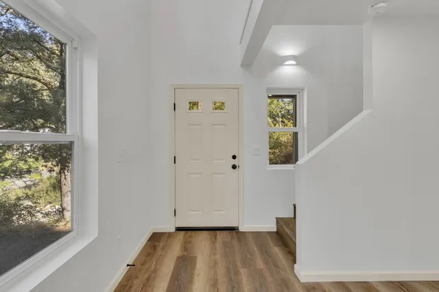 wooden floor in a hall with a window and a chandelier