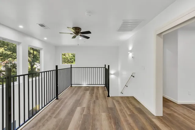 an empty room with wooden floor and windows