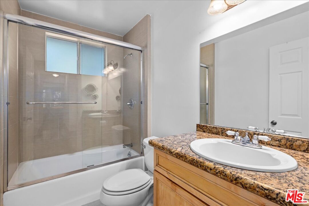 6867 Apperson Street Tujunga, CA 91042 - Photo 27 of 54 a bathroom with a granite countertop sink toilet and shower
