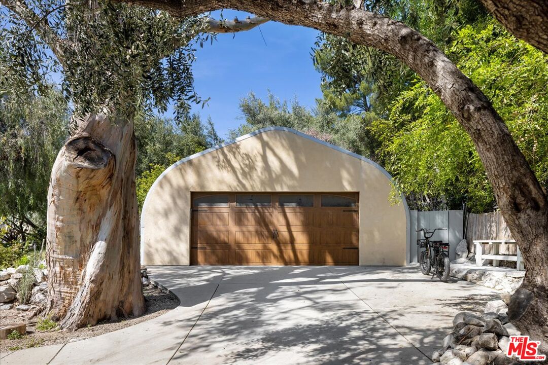 6867 Apperson Street Tujunga, CA 91042 - Photo 46 of 54 a backyard of a house with large trees and a wooden fence
