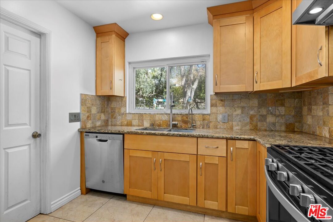 6867 Apperson Street Tujunga, CA 91042 - Photo 7 of 54 a kitchen with granite countertop white cabinets and a stove top oven