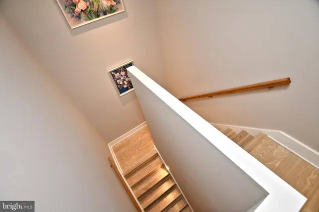 a view of staircase with wooden floor and white walls