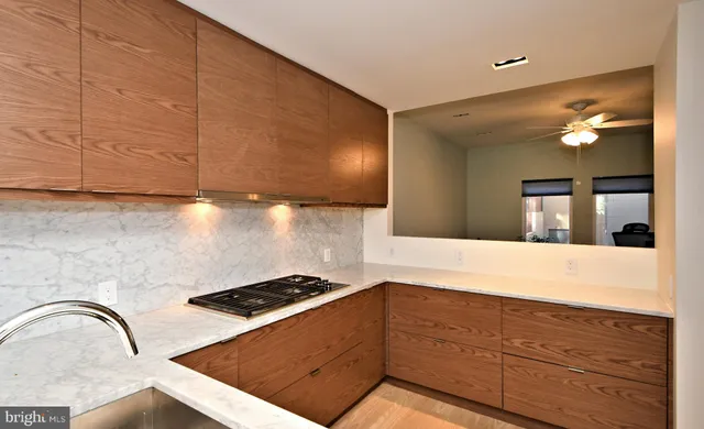 a kitchen with granite countertop white cabinets and stainless steel appliances
