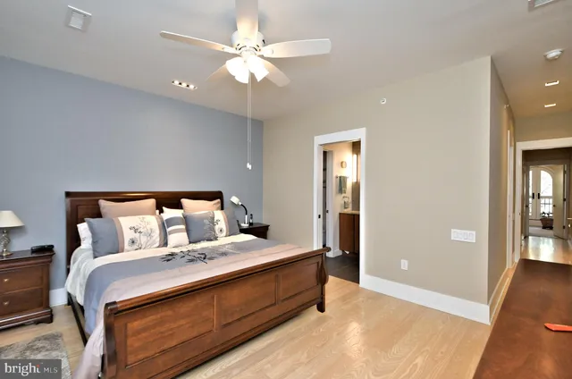 a bedroom with a bed and a mirror on dresser