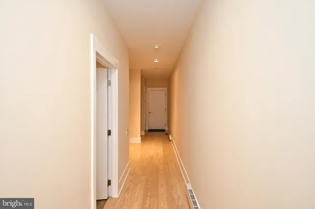 a view of a hallway with wooden floor