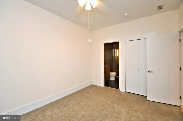 an empty room with a ceiling fan and window