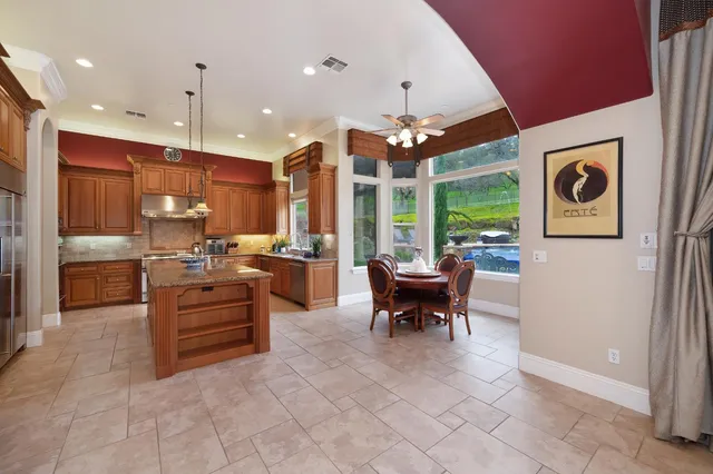 a dining room with furniture a kitchen and a chandelier