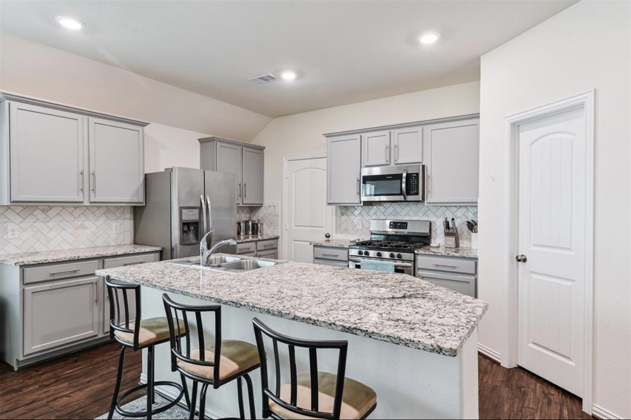 4639 Sequoia Echo Drive Spring, TX 77386 - Photo 5 of 26 a kitchen with stainless steel appliances granite countertop a stove a sink a microwave a refrigerator and cabinets