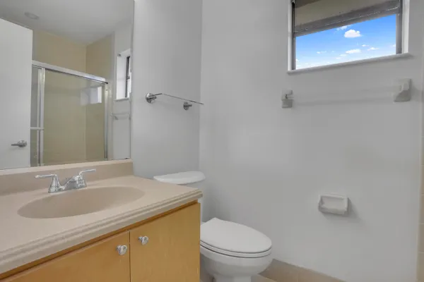 a bathroom with a granite countertop sink toilet and a mirror