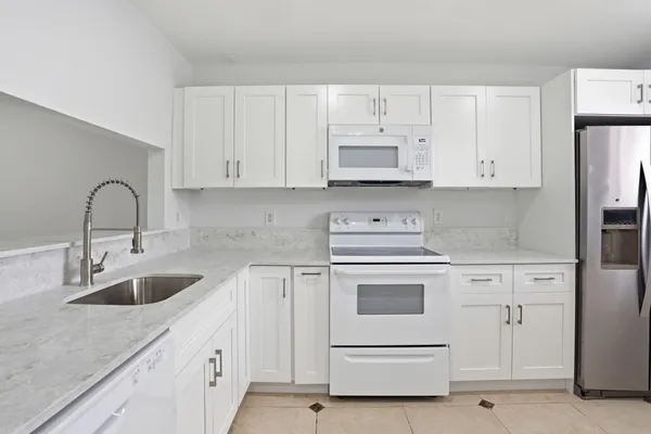 a kitchen with appliances a sink and cabinets