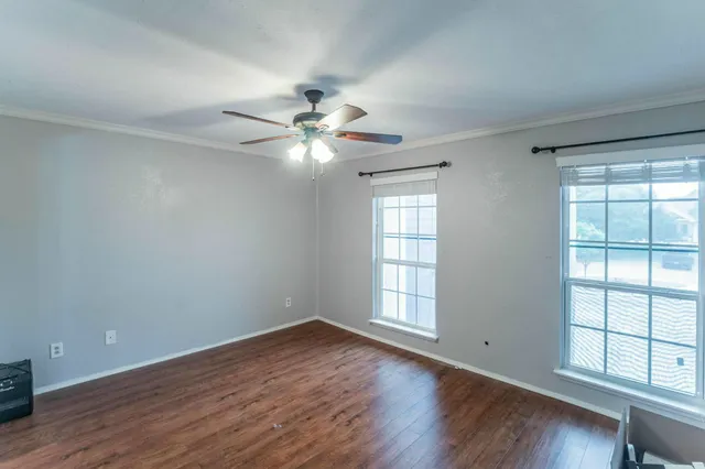a view of an empty room with wooden floor