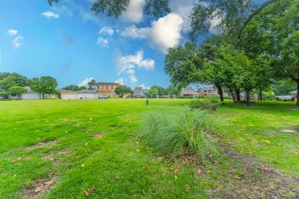 a view of grassy field with benches and trees all around