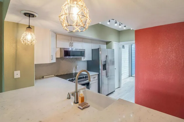 a view of an empty room with wooden floor fireplace and a window