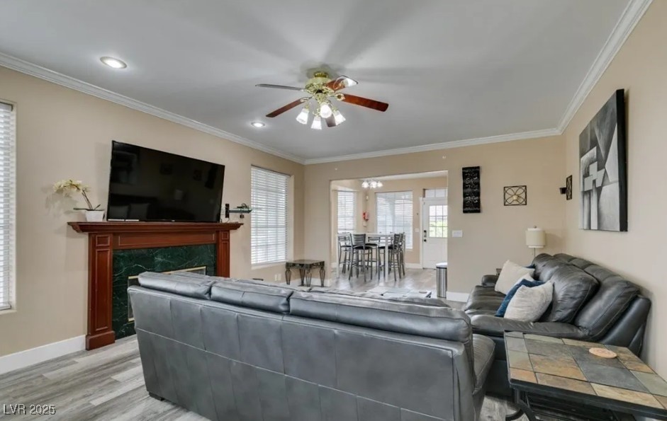 6520 Turtle Hill Road Las Vegas, NV 89110 - Photo 12 of 59 Living room with a premium fireplace, crown molding, a ceiling fan, light wood finished floors, and a chandelier