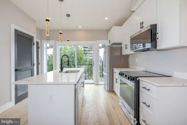 a kitchen with stainless steel appliances granite countertop a stove a sink and a refrigerator