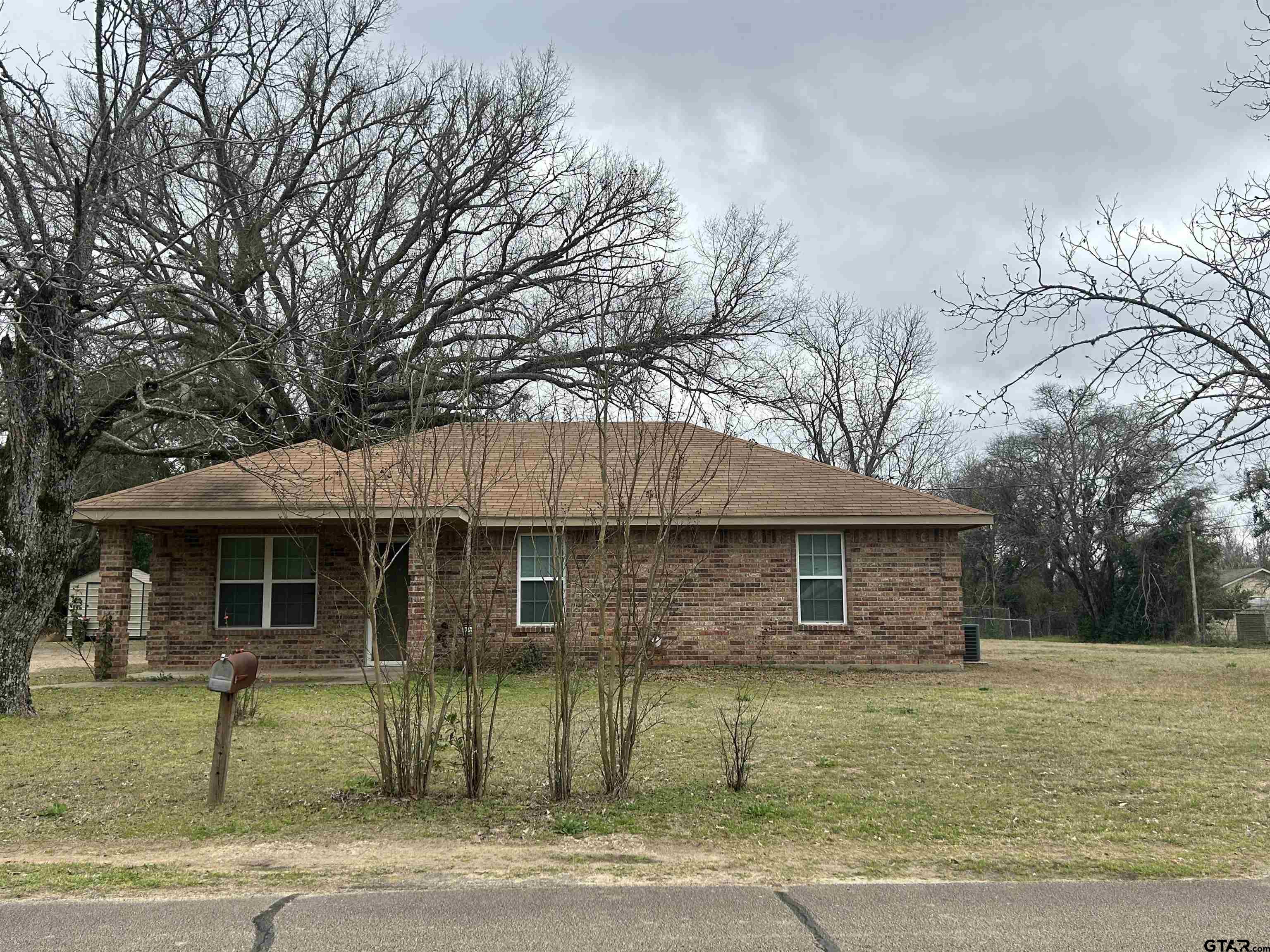 803 Sims Avenue Jacksonville, TX 75766 - Photo 16 of 18 a front view of a house with a garden