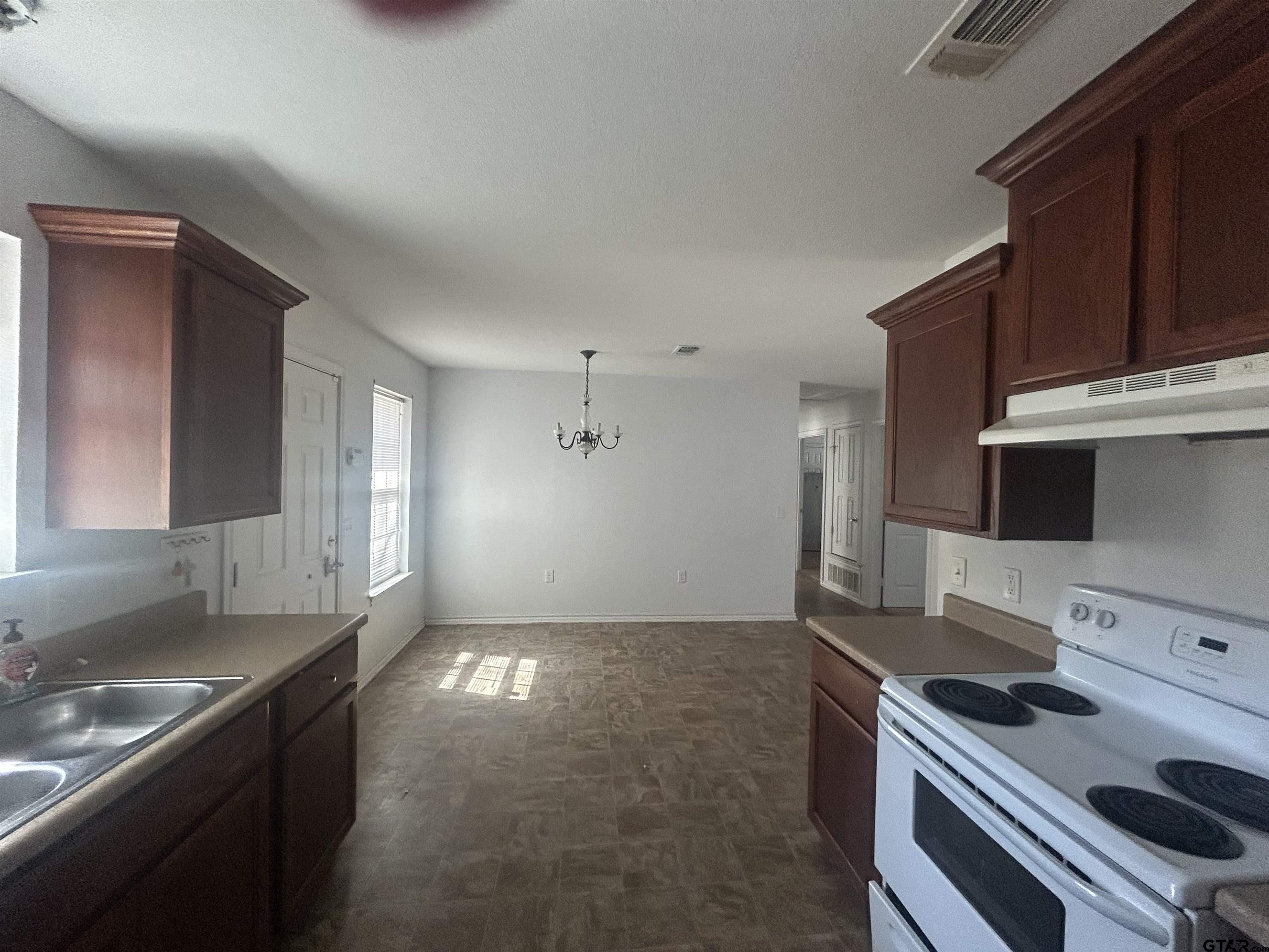 803 Sims Avenue Jacksonville, TX 75766 - Photo 5 of 18 a kitchen with granite countertop a stove and a sink