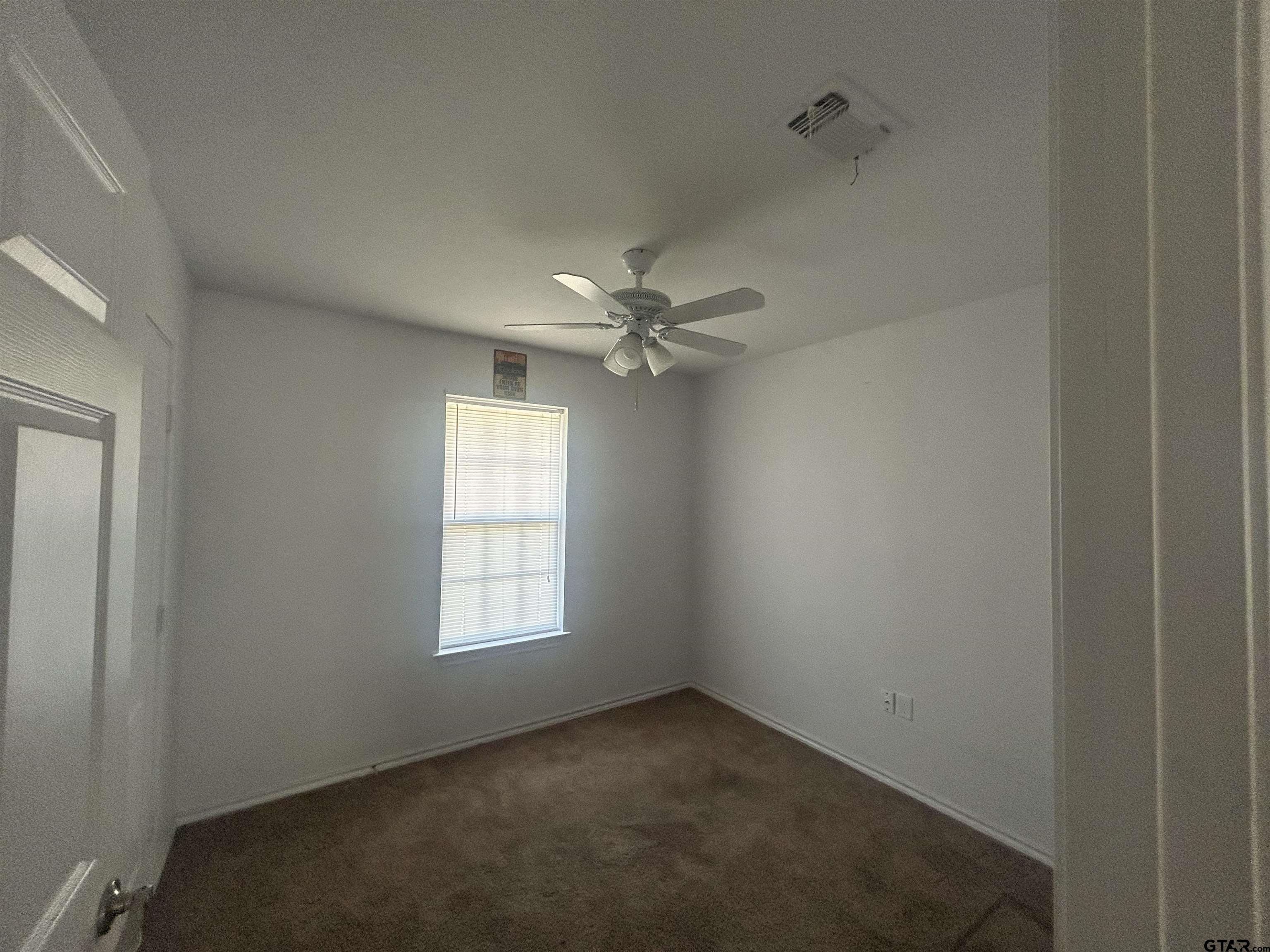 803 Sims Avenue Jacksonville, TX 75766 - Photo 7 of 18 an empty room with a window and a fan